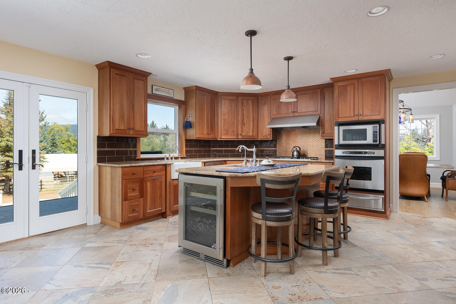 6905 Northeast Highland Road Otis, OR 97368 - Photo 19 of 76 a kitchen with stainless steel appliances granite countertop a stove top oven a refrigerator a sink a dining table and chairs with wooden floor