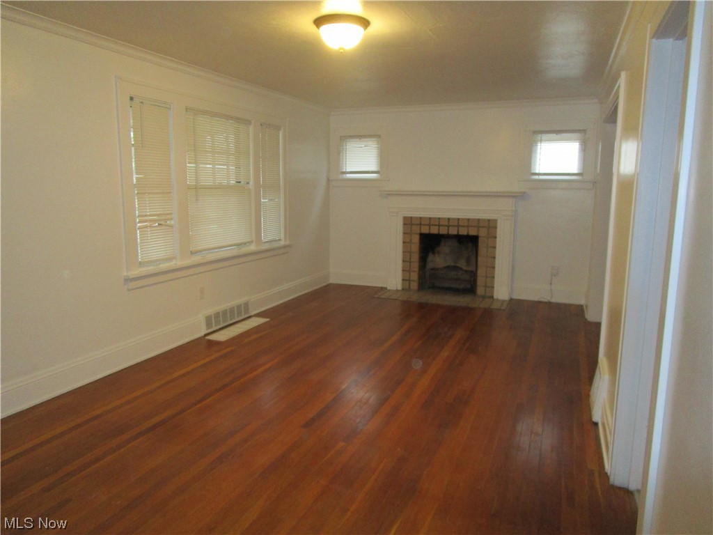 3796 Lowell Road Cleveland Heights, OH 44121 - Photo 3 of 11 Unfurnished living room with dark hardwood / wood-style flooring, ornamental molding, and a fireplace