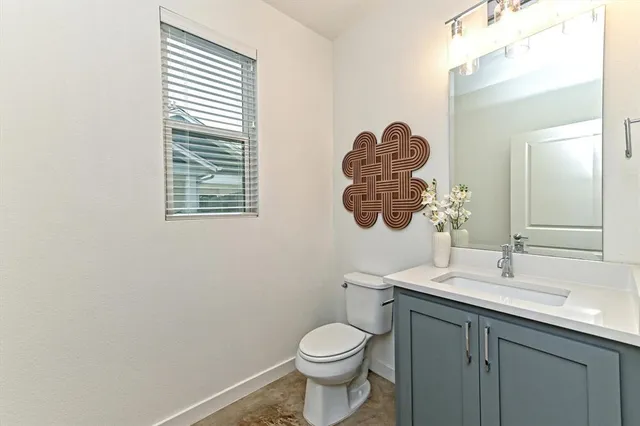 a bathroom with a toilet a sink a mirror and a window