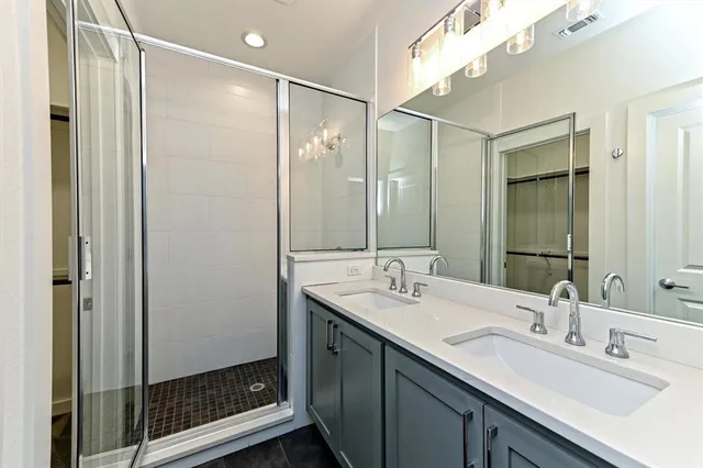 a bathroom with a double vanity sink mirror and shower