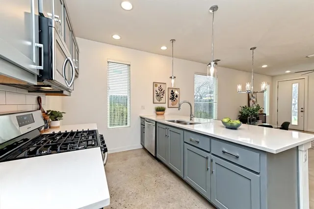 a kitchen with a sink and a stove top oven
