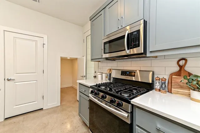 a kitchen with stainless steel appliances a stove a microwave and cabinets