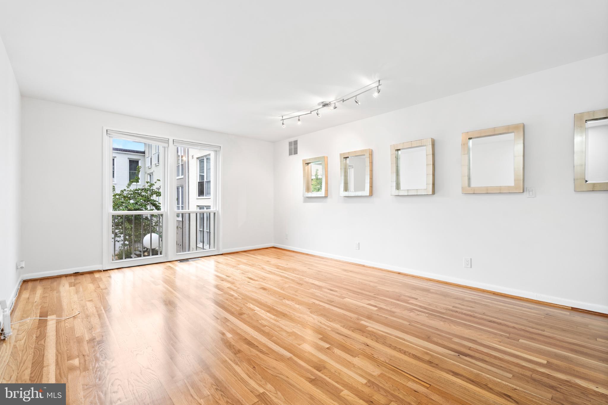 73 G Street Southwest, Unit 103 Washington, DC 20024 - Photo 13 of 35 a view of an empty room with wooden floor and a window