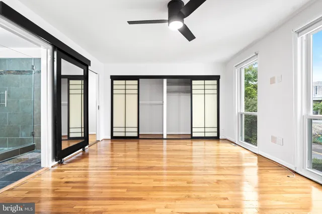 a view of an empty room with kitchen natural and wooden floor