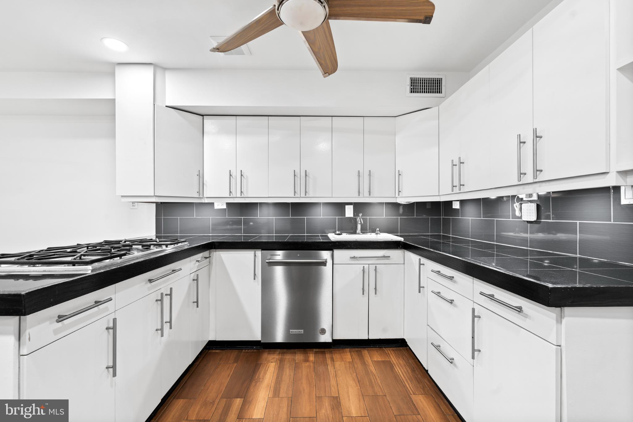 73 G Street Southwest, Unit 103 Washington, DC 20024 - Photo 5 of 35 a kitchen with granite countertop a stove and white cabinets