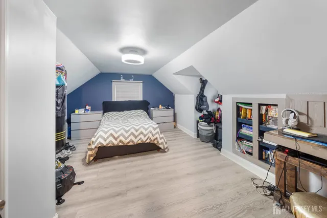 a bedroom with a bed and a wooden floor