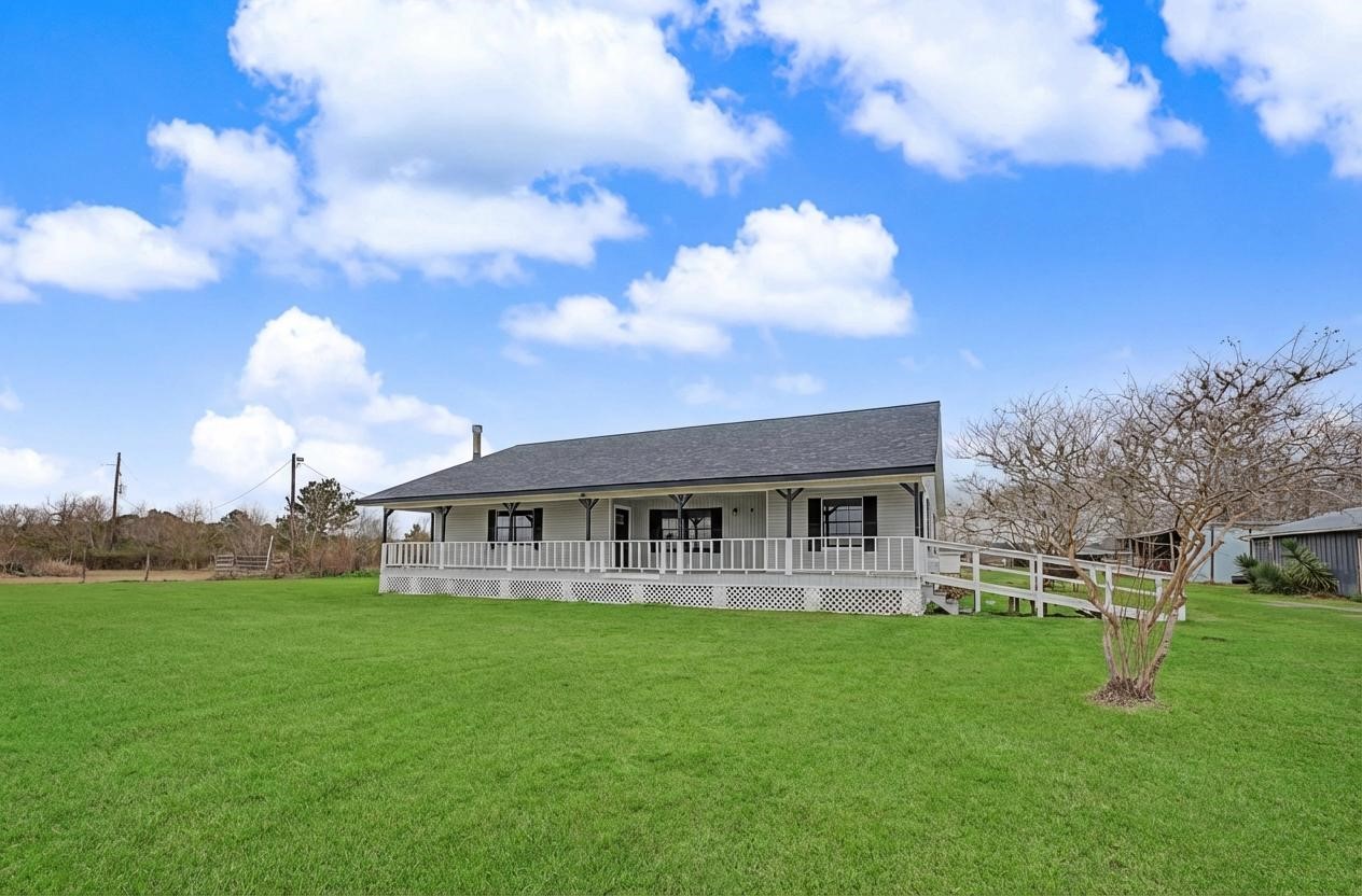 14077 Hamshire Road Hamshire, TX 77622 - Photo 1 of 39 Charming single-story home with a spacious wrap-around porch, set on a large, well-maintained lawn. Ideal for enjoying outdoor activities and scenic views.