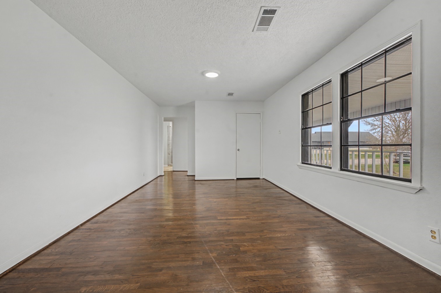 14077 Hamshire Road Hamshire, TX 77622 - Photo 16 of 39 This primary room features a bright, open layout with large windows and neutral walls, creating a welcoming and versatile living space.