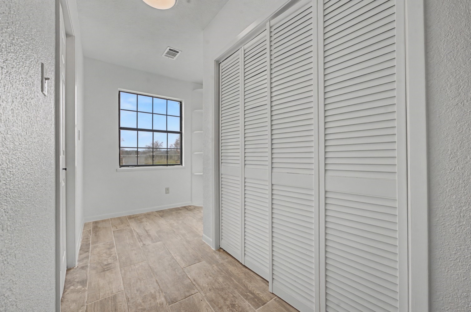 14077 Hamshire Road Hamshire, TX 77622 - Photo 19 of 39 Bright dressing area with a large window for natural light, and ample storage with white louvered closet doors.