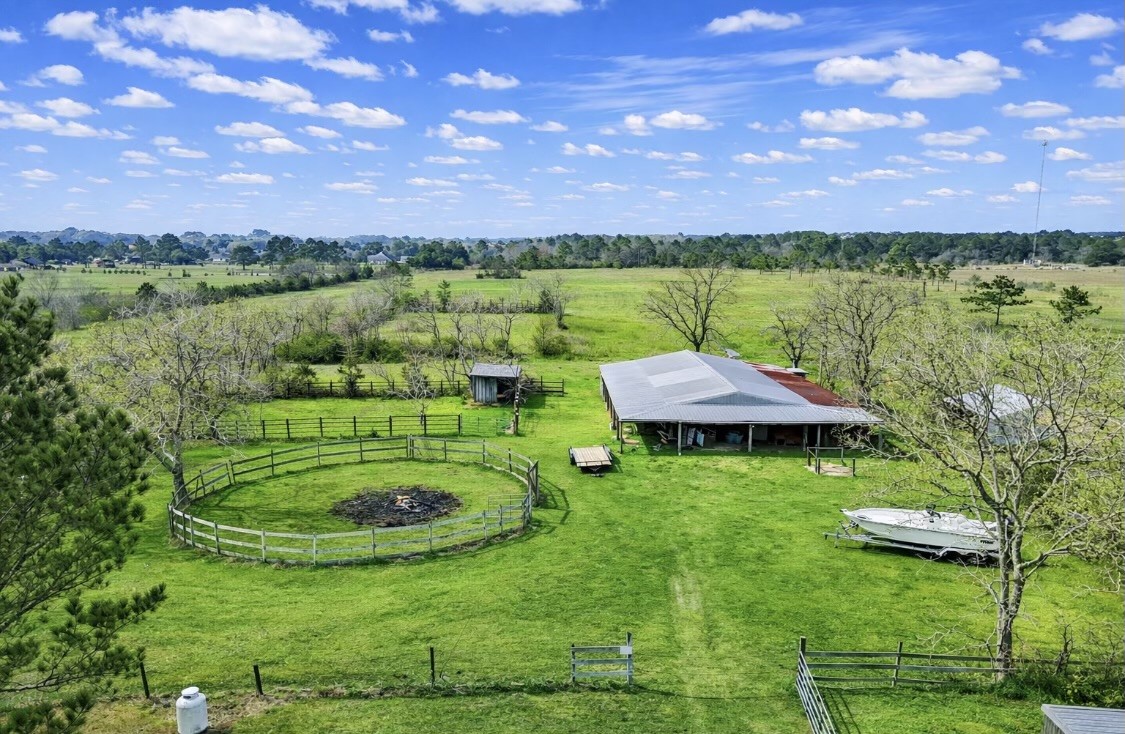 14077 Hamshire Road Hamshire, TX 77622 - Photo 37 of 39 This property features a spacious rural landscape with a large horse stables with 10 stalls, open pastures, and fenced areas, ideal for equestrian or farming activities. The serene setting offers expansive views and ample space for outdoor living.