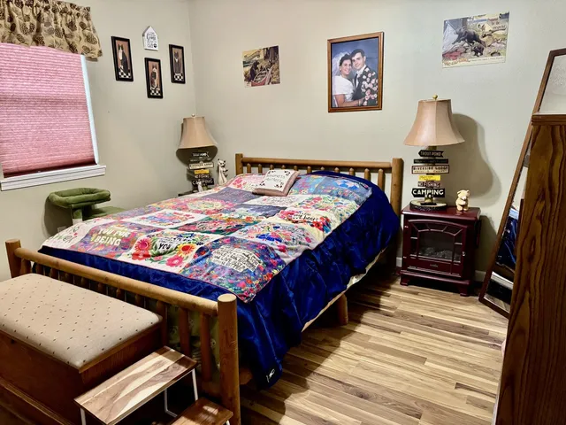 a bedroom with bed and wooden floor