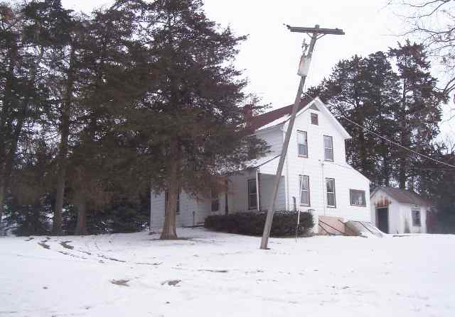 a view of a white house with a snow in the yard
