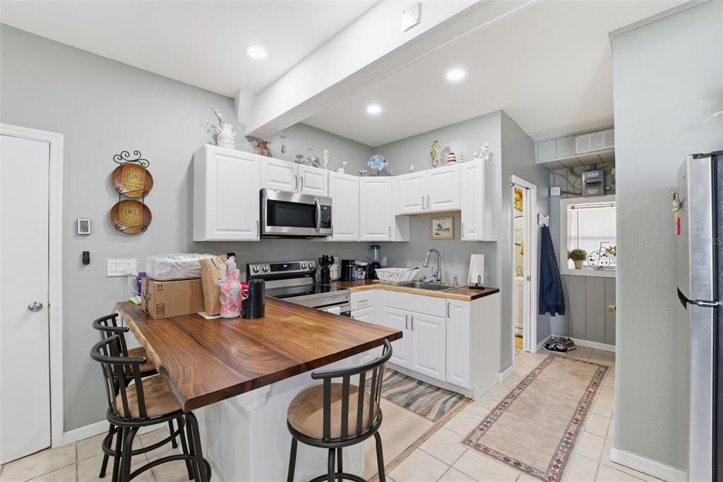 3366 Bluefish Drive Hernando Beach, FL 34607 - Photo 23 of 75 a kitchen with a table chairs refrigerator and microwave