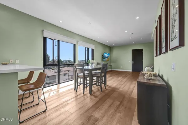 a dining room with wooden floor a glass table and chairs