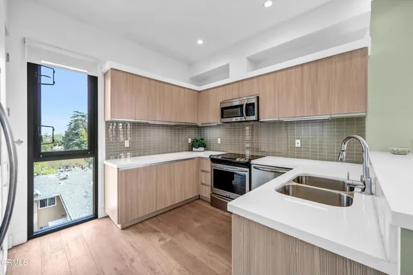 a kitchen with a sink stove top oven and cabinets