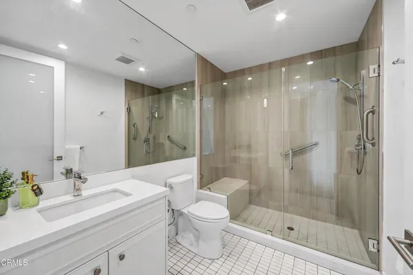 a bathroom with a shower sink vanity mirror and toilet