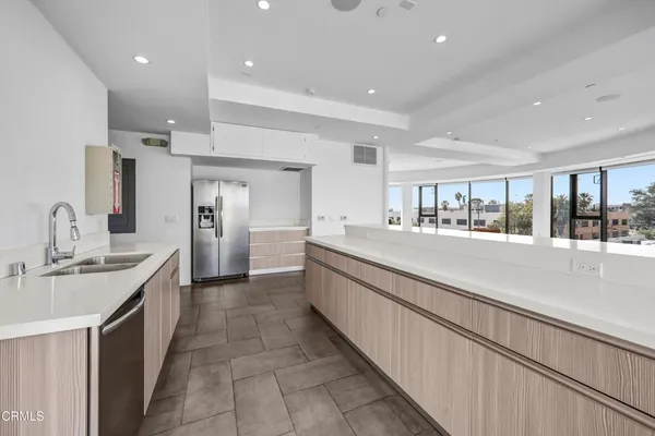 a large kitchen with kitchen island a sink stainless steel appliances and cabinets