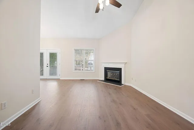 a view of empty room with wooden floor and ceiling fan