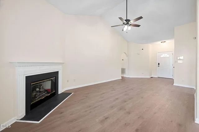 a view of an empty room with a window and fireplace