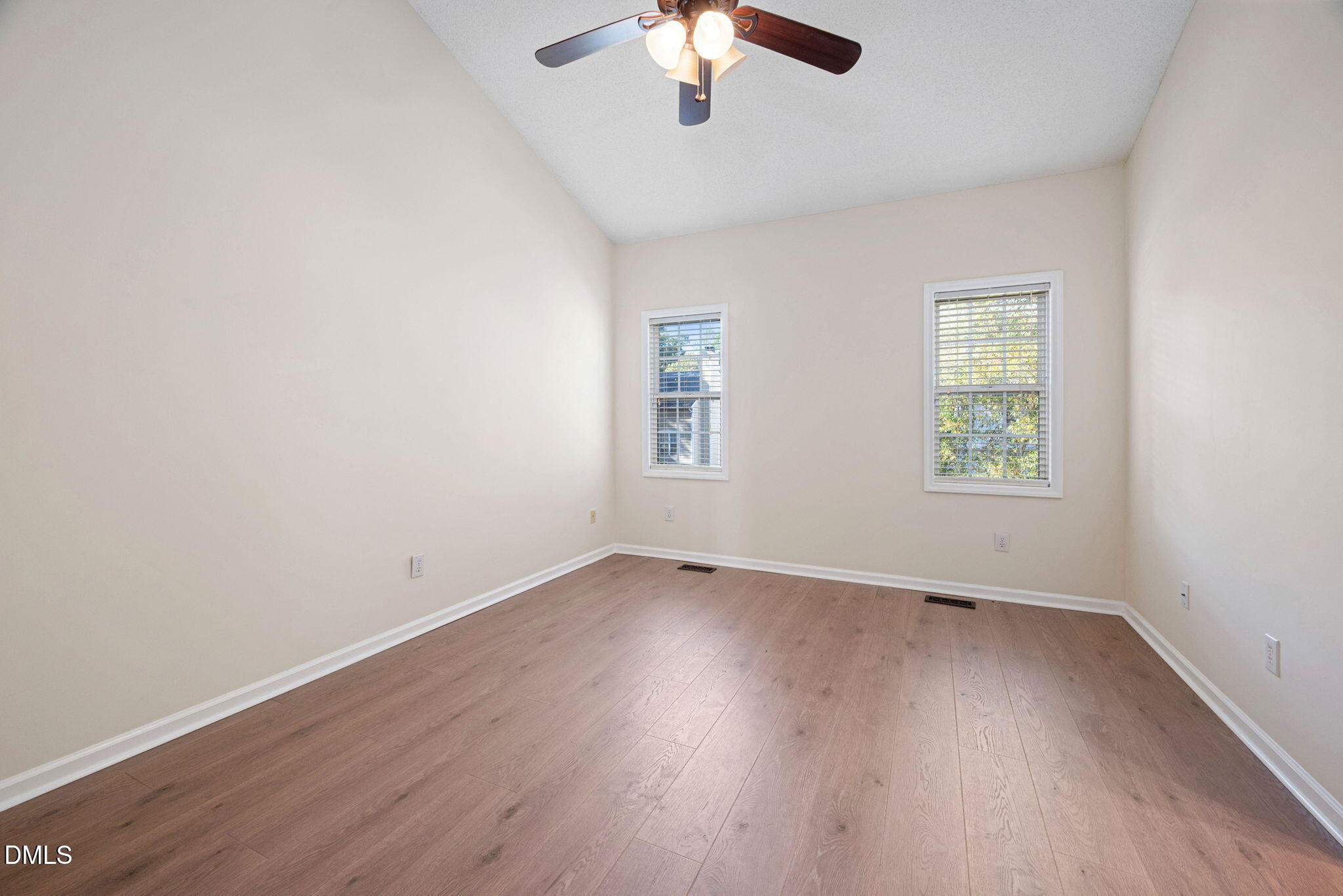 2524 Beech Gap Court Raleigh, NC 27603 - Photo 17 of 31 an empty room with wooden floor chandelier fan and windows
