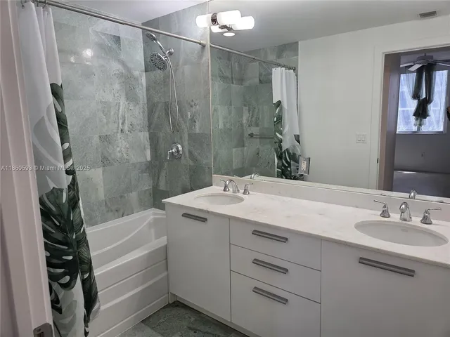 a bathroom with a granite countertop sink a toilet and shower