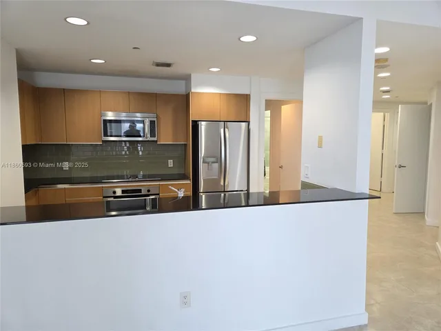 a view of a room with a ceiling fan and wooden floor