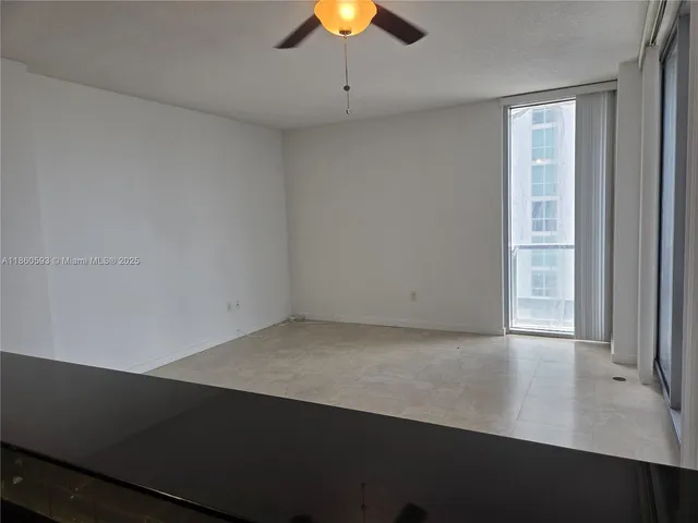 an empty room with a ceiling fan and window