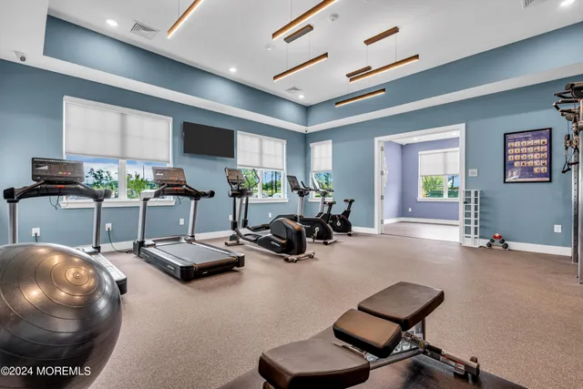 a kitchen with stainless steel appliances granite countertop wooden floors wooden cabinets dining table and chairs