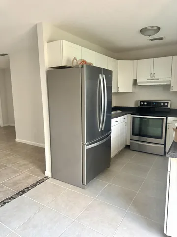 a kitchen with stainless steel appliances granite countertop a refrigerator and a stove