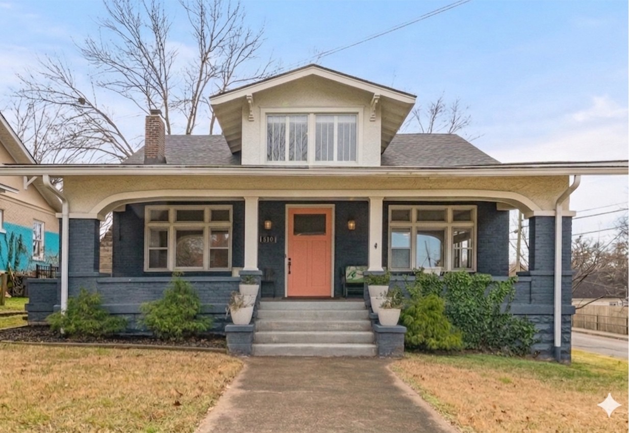 front view of a brick house with a small yard