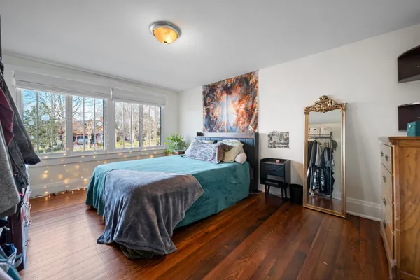 a bedroom with a bed and a painting on the wall