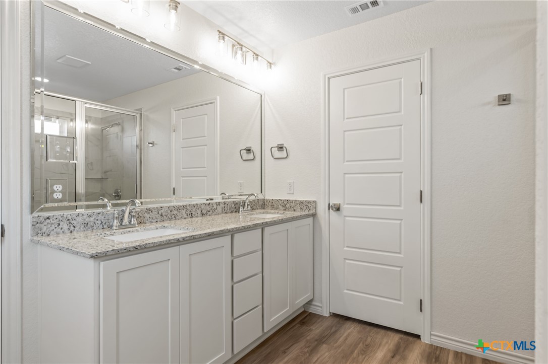 1204 Victory Ranch Trail Killeen, TX 76549 - Photo 16 of 33 a bathroom with a granite countertop sink and a mirror