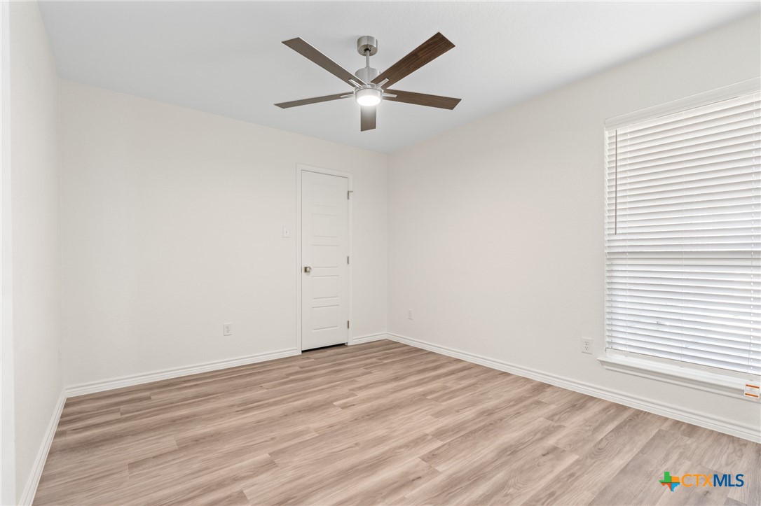1204 Victory Ranch Trail Killeen, TX 76549 - Photo 19 of 33 an empty room with wooden floor and ceiling fan