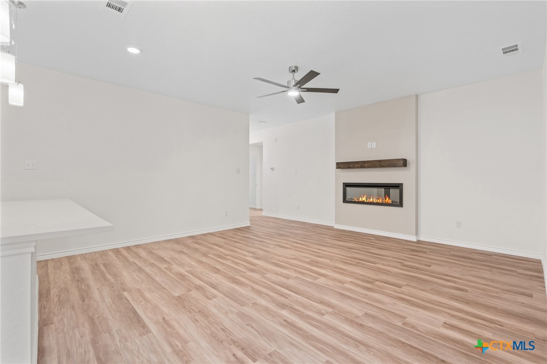 1204 Victory Ranch Trail Killeen, TX 76549 - Photo 7 of 33 a view of empty room with wooden floor and fan