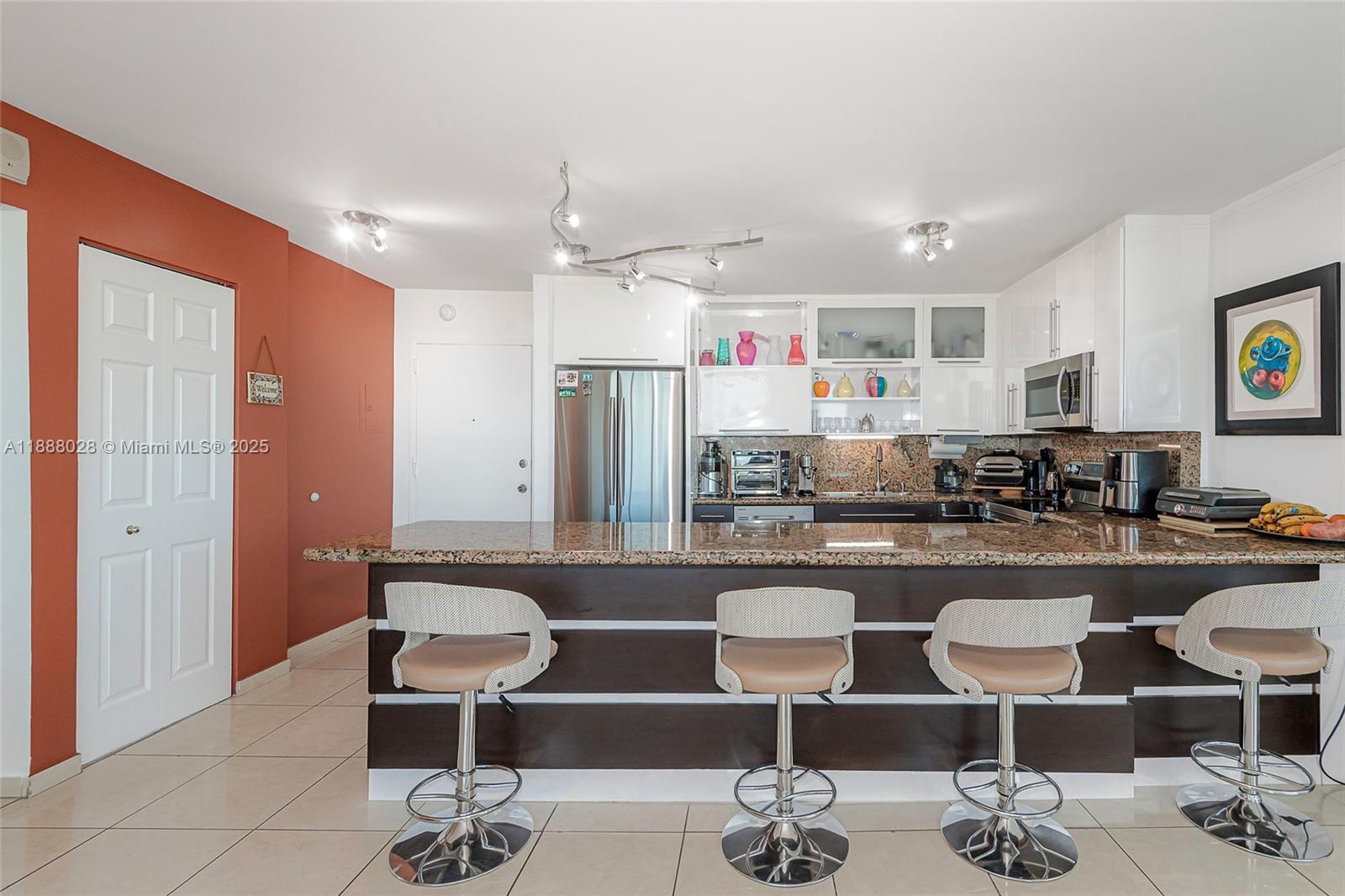 7135 Collins Avenue, Unit 625 Miami Beach, FL 33141 - Photo 13 of 33 a kitchen with a dining table and chairs