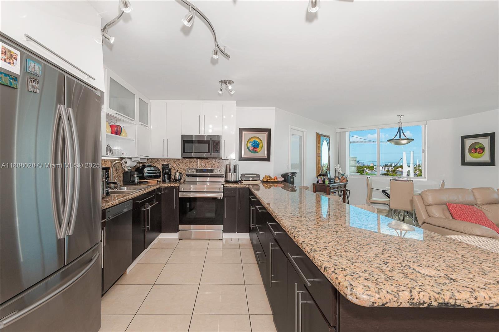 7135 Collins Avenue, Unit 625 Miami Beach, FL 33141 - Photo 17 of 33 a large kitchen with granite countertop a large counter top stainless steel appliances and cabinets
