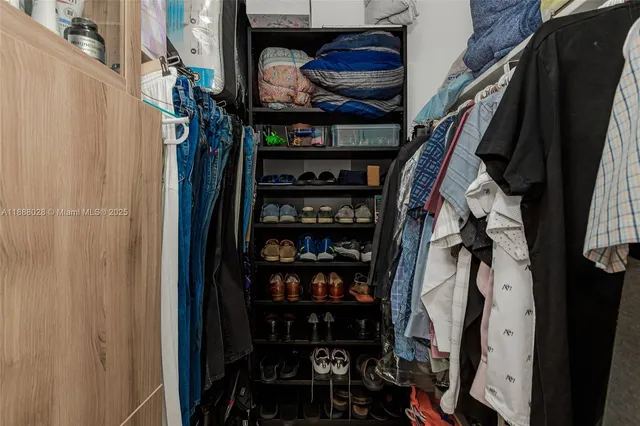 a view of walk in closet with clothes and shoes