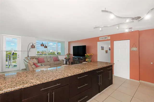 a kitchen with granite countertop a sink and a wooden floor