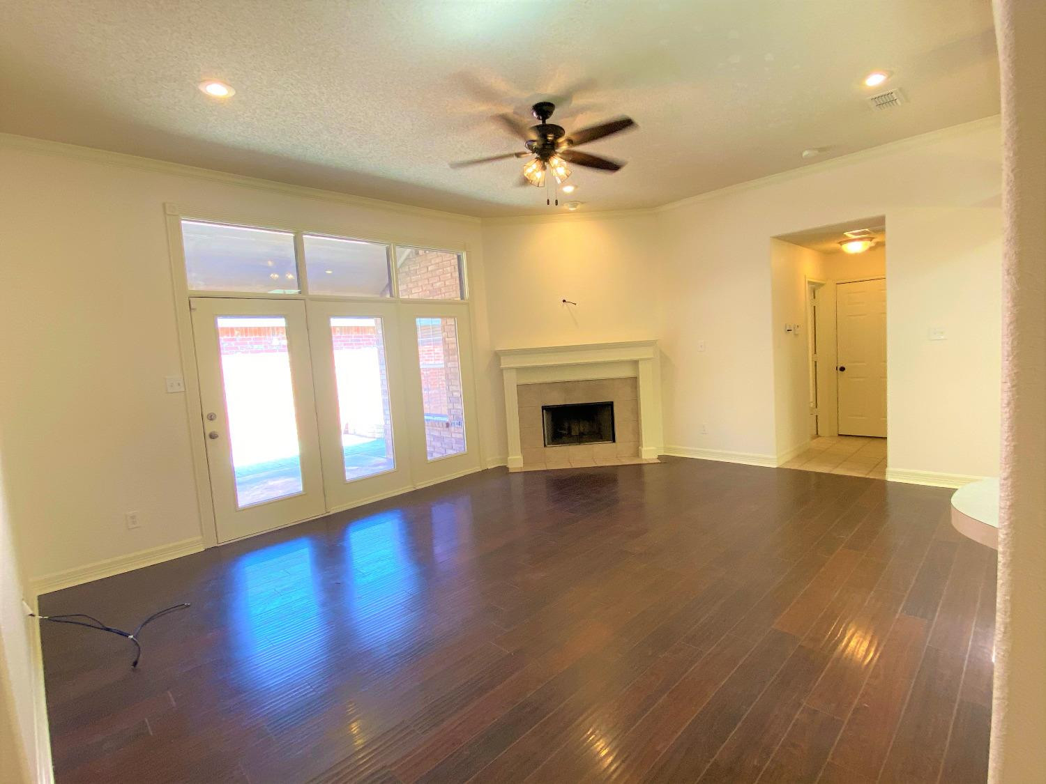 6521 8th Street Lubbock, TX 79416 - Photo 11 of 25 a view of an empty room with window and wooden floor