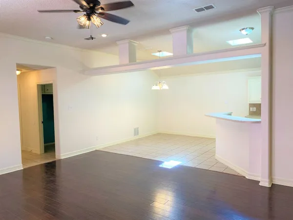 a view of an empty room with wooden floor