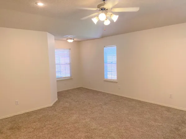 en empty room with windows and fan