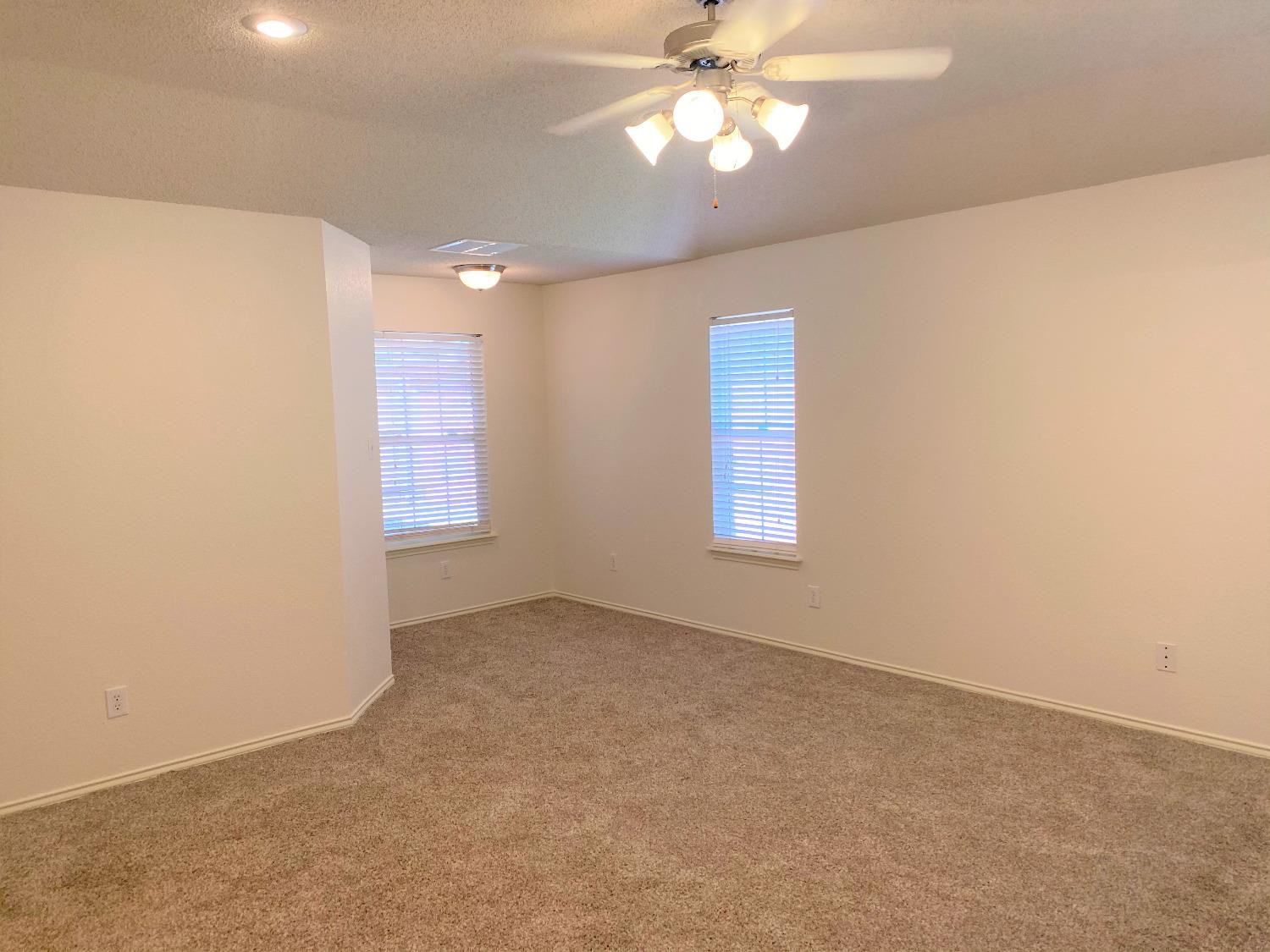 6521 8th Street Lubbock, TX 79416 - Photo 16 of 25 en empty room with windows and fan