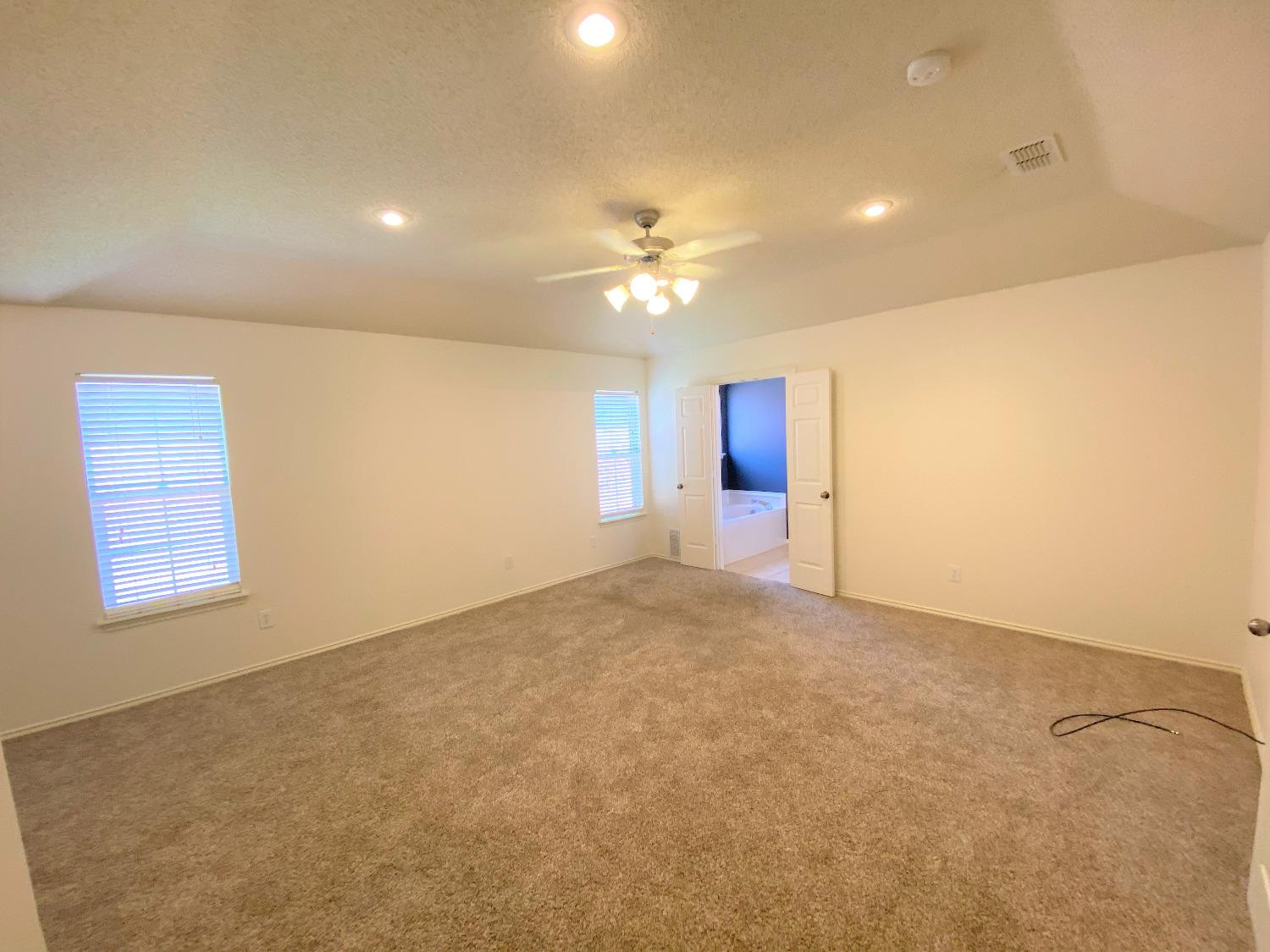 6521 8th Street Lubbock, TX 79416 - Photo 17 of 25 an empty room with windows and ceiling fan