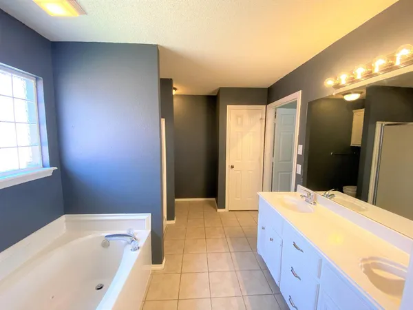 a spacious bathroom with a tub shower and sink