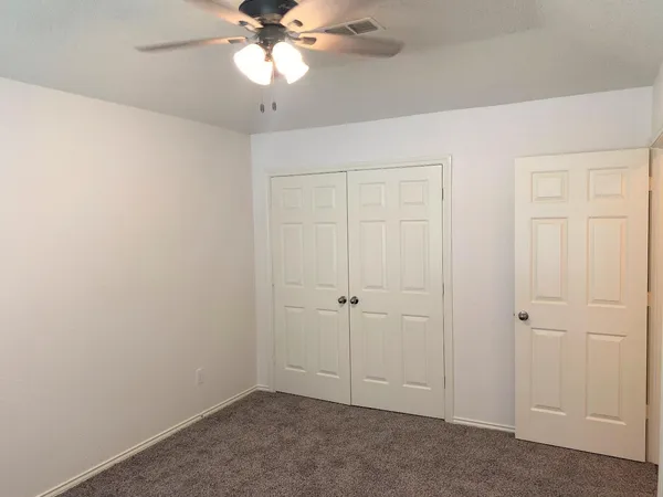 an empty room with a chandelier fan