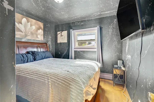 a bedroom with a bed and a painting on the wall