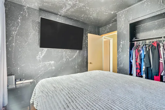 a bedroom with a bed and a flat screen tv