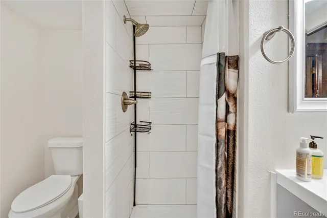 a bathroom with a toilet and a shower