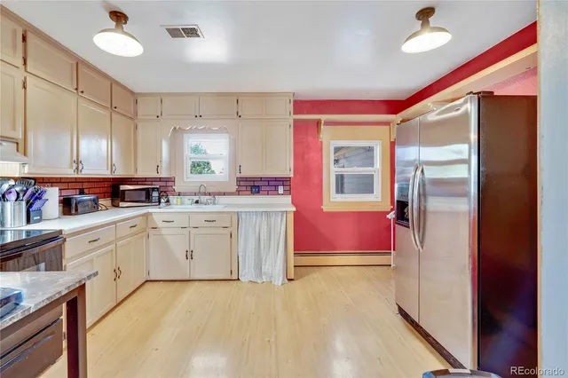 a large kitchen with a stove a sink dishwasher and a refrigerator