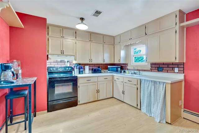 a kitchen with granite countertop a sink stainless steel appliances and cabinets